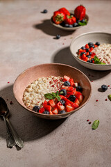 Oatmeal porridge with berries and mint in bowls on the table for a delicious and healthy breakfast
