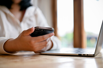 Close-up image of a woman using her smartphone, texting or sending SMS