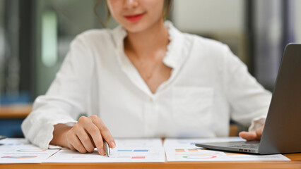 Close up of business woman analyzing financial data, business planning, financial documents, graphs and charts.