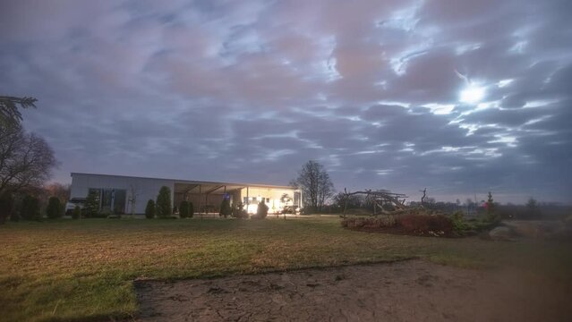 Timelapse of thick cloud cover over eerie farm structure with fresh laid grass
