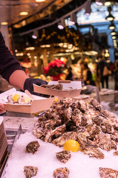 Unrecognizable person holding fresh oysters at market