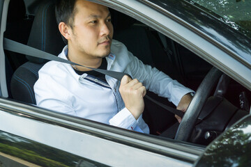 Young asian man sitting on car seat and fastening seat belt. Safety belt safety first while driving. Handsome inside car fastening seat belt. Safe driving while driving concept.