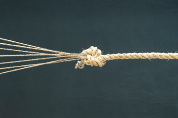 The connection of a twisted rope and several ropes with a knot. Teamwork, communication, help.