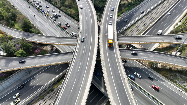 Aerial drone top down photo of multilevel bridge highway road interchange passing near urban residential area during rush hour