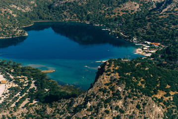 Obraz premium Amazing view of Blue Lagoon in beach resort in the Fethiye district - Oludeniz. Turkey. Summer landscape with mountains, green forest, turquoise coast in bright sunny day. Travel background.