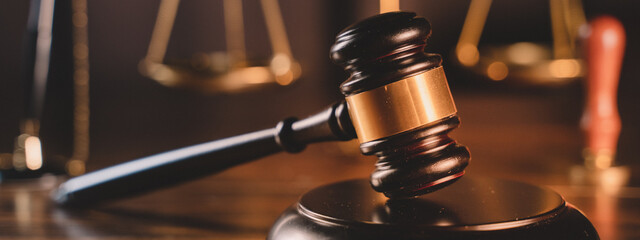 banner background of law and authority lawyer concept. Hammer and scales of justice in a courtroom...