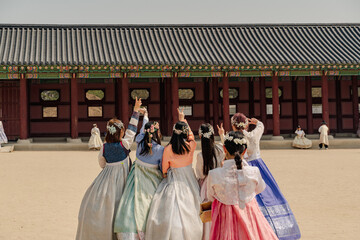 Korean girls in Hanbok or Korean dress. Young women having fun taking pictures in Gyeongbokgung Palace, tourism in korea. - obrazy, fototapety, plakaty