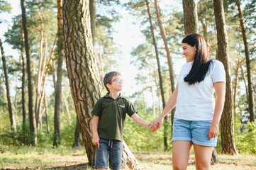 Cute little boy in his mother walk in nature.