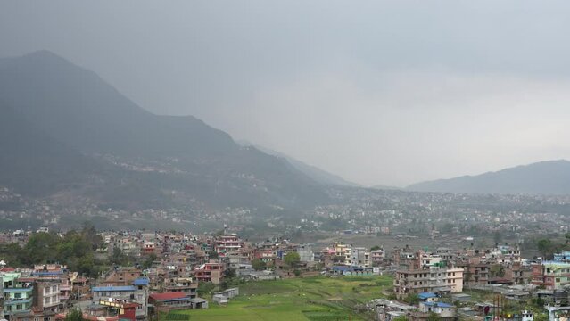 A panning view of the mountains surrounding a small city nestled in the Himalaya Foothills of Nepal.