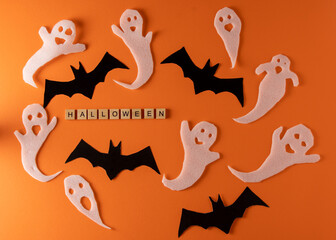 Naklejka premium White ghosts and bat craft for Halloween party. Wrapping paper ghost on orange background top view. Cartoon creepy Whisper. DIY hand made. Set boo characters. Word wooden letter phrase.
