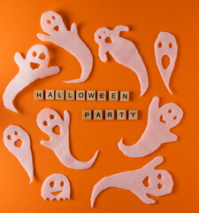 White ghosts craft for Halloween party. Wrapping paper ghost on orange background top view. Cartoon creepy Whisper. DIY hand made. Set boo characters. Word wooden letter phrase.