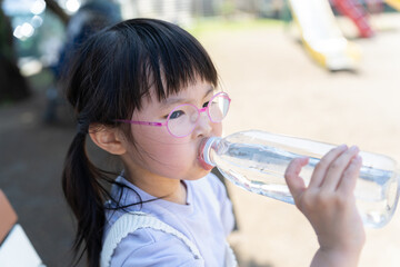 ペットボトルの水を飲む子供（熱中症対策・水分補給・夏）