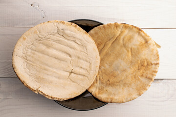 Two baked  pita, close-up, on a wooden table, top view.