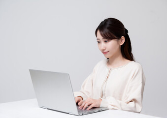 ノートパソコンに向かう若い女性ロングヘア仕事風景