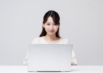 ラップトップパソコンに向かう若い女性ロングヘア白い背景