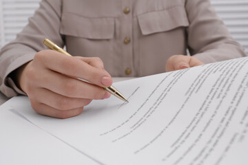 Naklejka premium Woman signing document with pen, closeup view