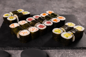 Sushi rolls set on dark background. Japanese and asian food concept
