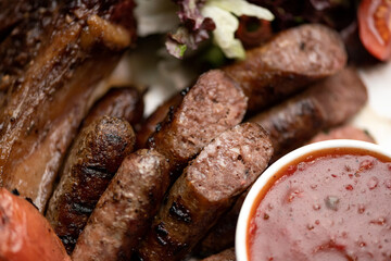 Fried sausages with tomato sauce. Fried meat snacks. Close-up. View from above. Soft focus.