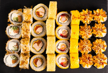 Sushi rolls set on dark background. Japanese and asian food concept
