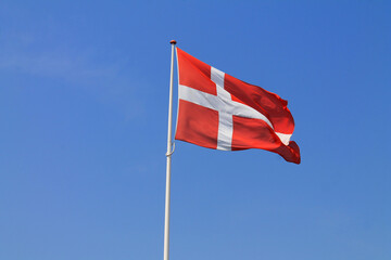 Danish flag in the blue sky on a sunny summer day in Denmark