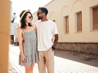 Smiling beautiful woman and her handsome boyfriend. Woman in casual summer clothes. Happy cheerful family. Female having fun. Sexy couple posing in the street at sunny day. In hat and sunglasses