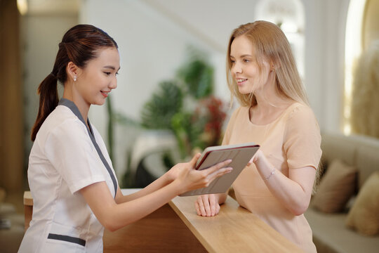Spa salon receptionist talking to client offering new procedure