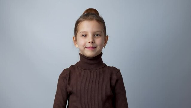 Portrait of child 6 years old girl looking at camera waving hello greeting