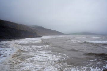 Stormy weather with waves crashing on rocks 