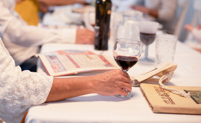 On white served traditional table with haggadah prepared for Passover with matza, egg,  wine,...