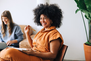 Black businesswoman smiling cheerfully while sitting in a meeting