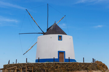 Old restored windmill in Aljezur, Portugal, against of the blue sky
