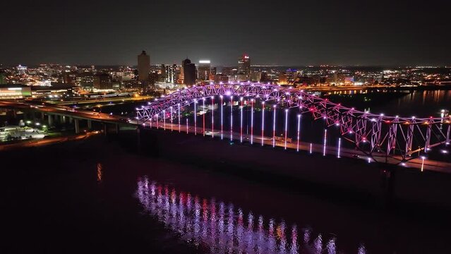 Hernado De Soto bridge in Memphis, Tennessee with illuminated Mighty Lights at night with drone video pulling back.