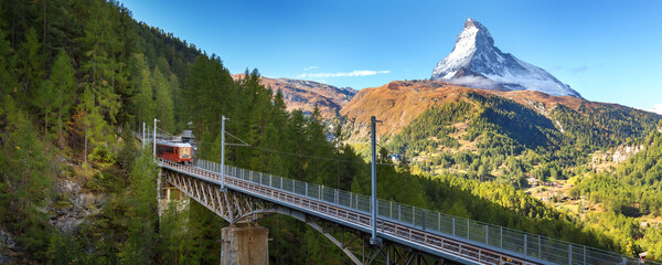 Zermatt, Switzerland. Gornergrat red tourist train on the bridge and Matterhorn peak panorama in...