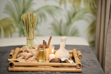 Tray with massage oils, ginger, candles basalt stones and massage sacks