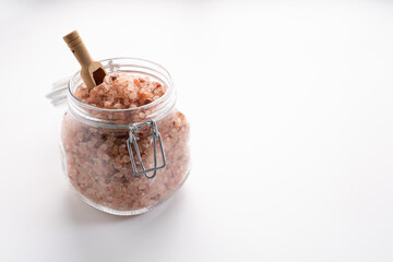 Himalayan pink salt on glass of jar isolated on white background with copyspace