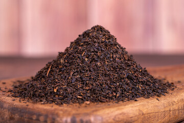 Black tea. Dried black sea tea on wood background. Close up