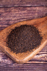 Black tea. Dried black sea tea on wood background