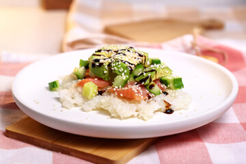 Sushi Waffle is crispy rice, made in a waffle maker, topped with shoyu salmon, crunchy cucumber