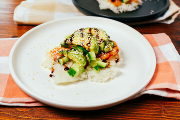 Sushi waffle is a cooking process. Culinary trend made with crispy rice waffles and sprinkled with salmon, cucumber and avocado.