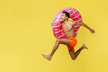 Full body side profile view young sexy man wear orange shorts swimsuit relax near hotel pool jump...