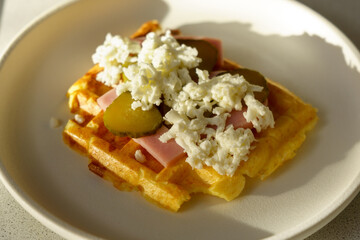 Waffle pizza with ham and pickled cucumbers and cheese. Hybrid food, piffle