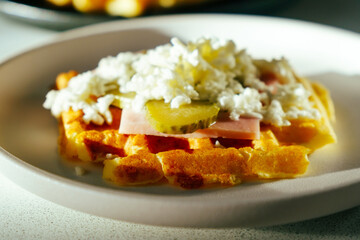 Waffle pizza with ham and pickled cucumbers and cheese. Hybrid food, piffle