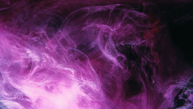 Color mist. Glitter smoke. Paint water splash. Magic potion. Purple pink glowing sparkling particles fog floating on dark black abstract art background with free space.