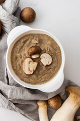 Mushroom cream soup in a plate, delicious healthy soup with Eringi and Champignons, fresh mushrooms...