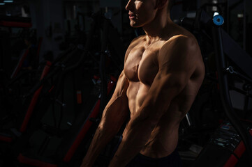Obraz na płótnie Canvas Shirtless man with sculpted body in the gym. 