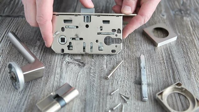 The man dismantled the internal door lock, repaired and oiled it