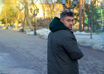 handsome man with beard walking in a park enjoys fresh air spring