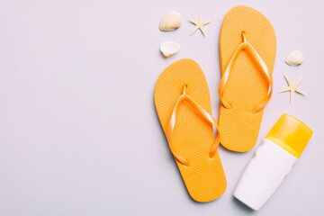 Summer travel concept. Beach accessories. Flip flops and starfish on white. Top view on colored background