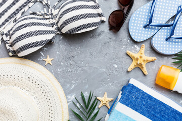 Woman swimwear and beach accessories flat lay top view on colored background Summer travel concept. bikini swimsuit, straw hat and seasheels. Copy space Top view