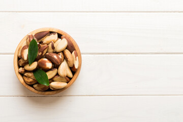 Fresh healthy Brazil nuts in bowl on colored table background. Top view Healthy eating bertholletia concept. Super foods